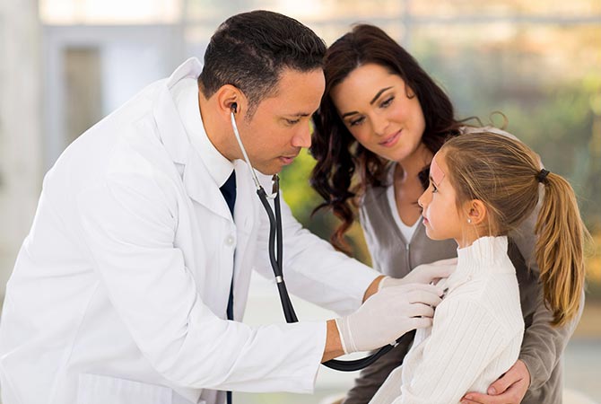 Doctor listening young girls heart and mother watching